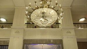 A grand lobby with a large chandelier, a bar area, and classical architecture. - Magnolia Hotel St. Louis, a Tribute Portfolio Hotel (St. Louis)