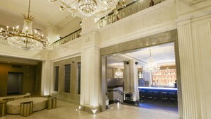 A grand lobby with a bar area, chandeliers, and seating. - Magnolia Hotel St. Louis, a Tribute Portfolio Hotel (St. Louis)