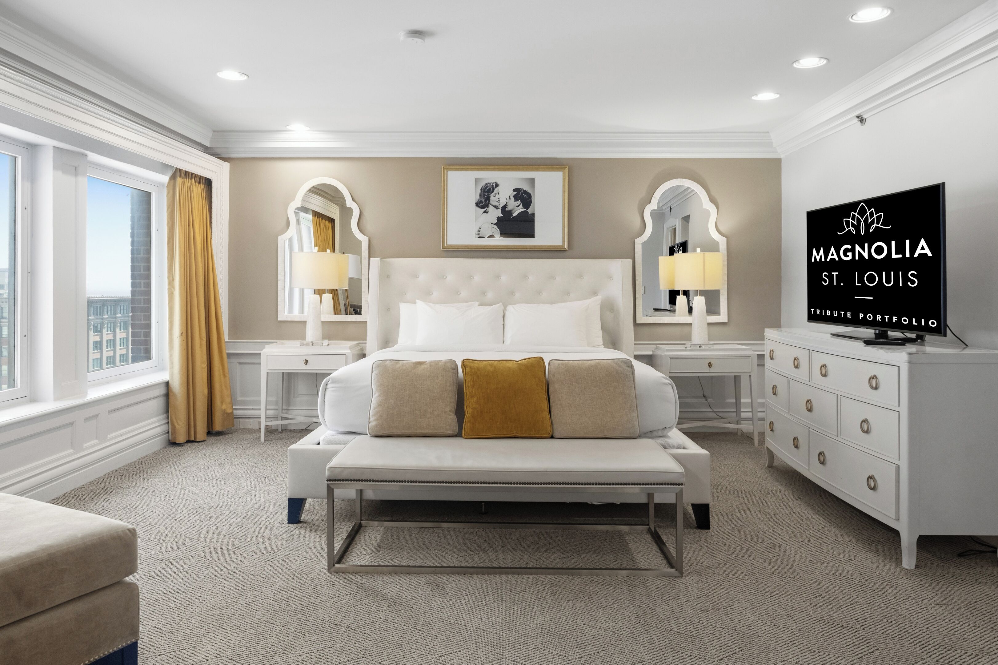 A hotel room with a large bed, two bedside tables, a dresser, a television, and a window with curtains.