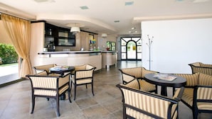 A modern kitchen with a bar area, dining chairs, and a large window. - Residence Besàss (Tignale)