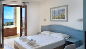 A bedroom with a bed, a nightstand, a desk, and a painting on the wall. - Residence Besàss (Tignale)