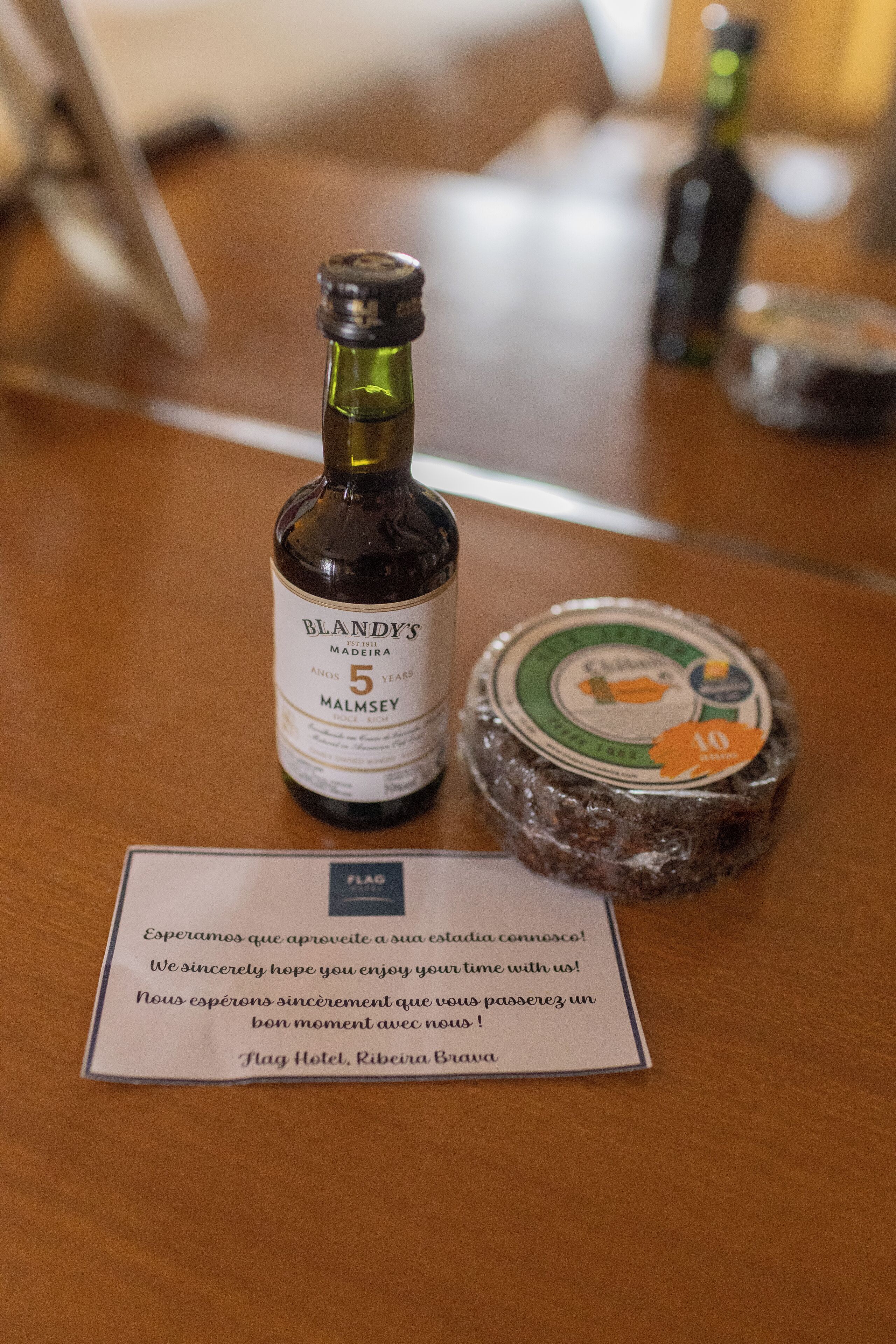 A bottle of Blandy's Madeira on a wooden table with a coaster and a sign.