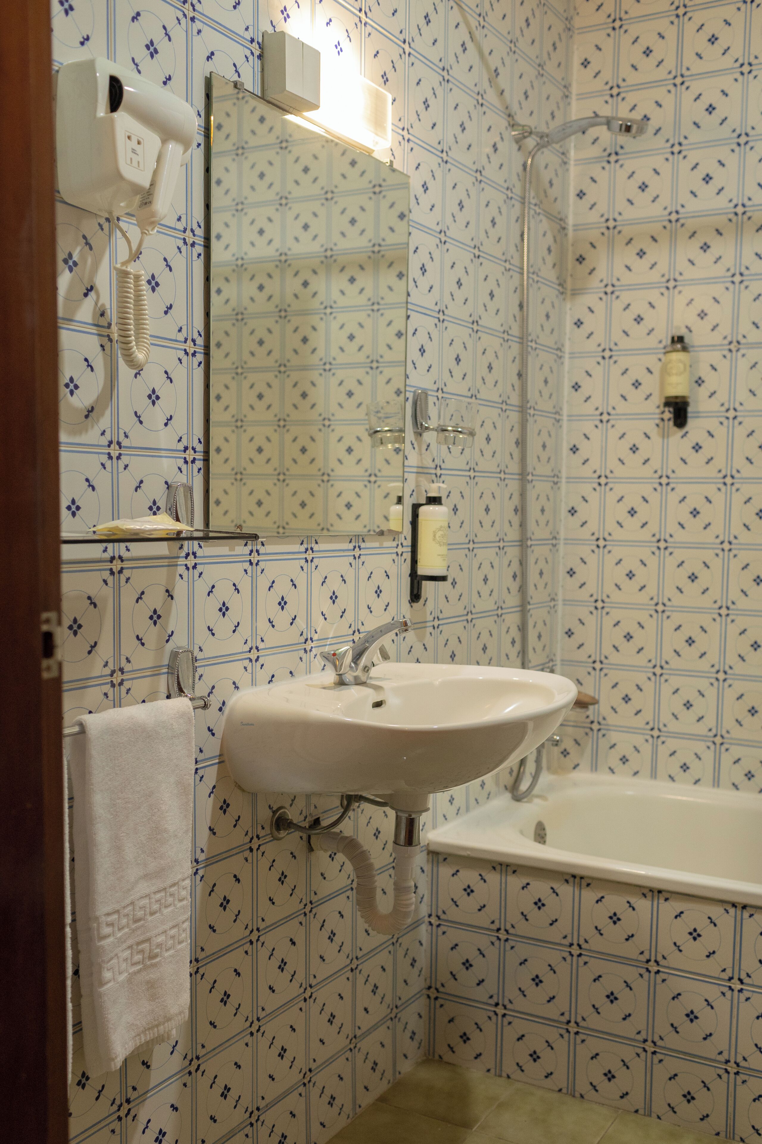A bathroom with a sink, mirror, and shower.