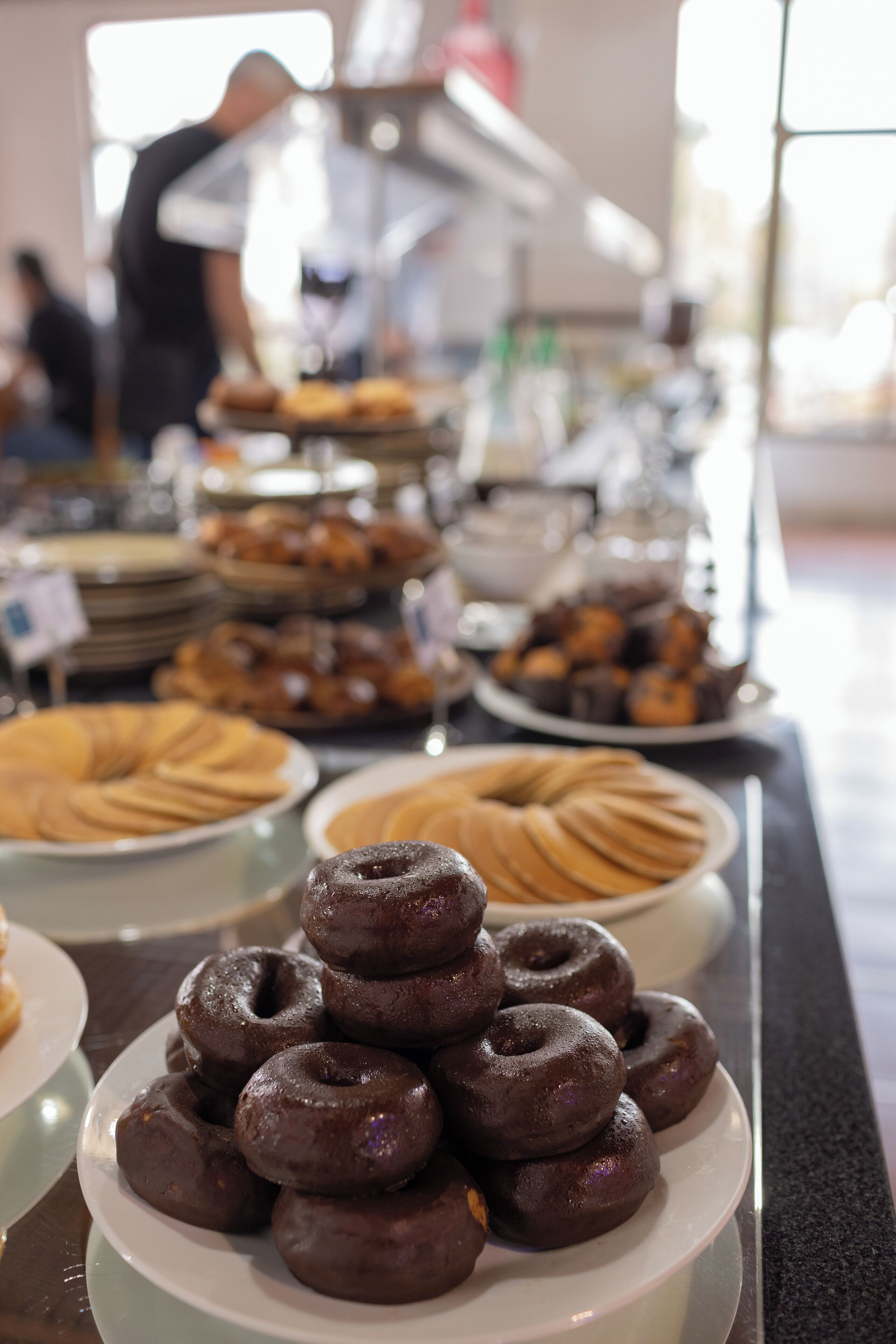 A buffet with various baked goods including donuts and pastries.