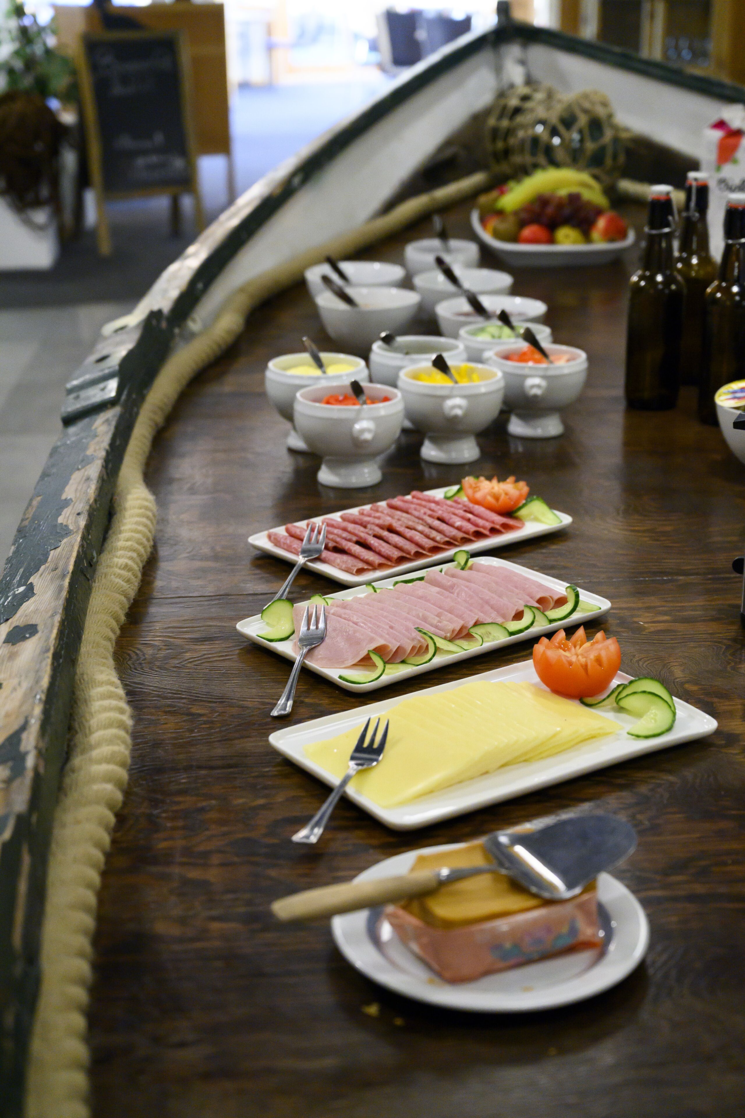Uma mesa de buffet com diversos alimentos e acompanhamentos.