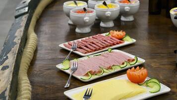 Uma mesa de buffet com diversos alimentos e acompanhamentos.