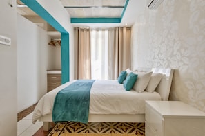 A modern bedroom with a bed, nightstands, and a patterned rug.