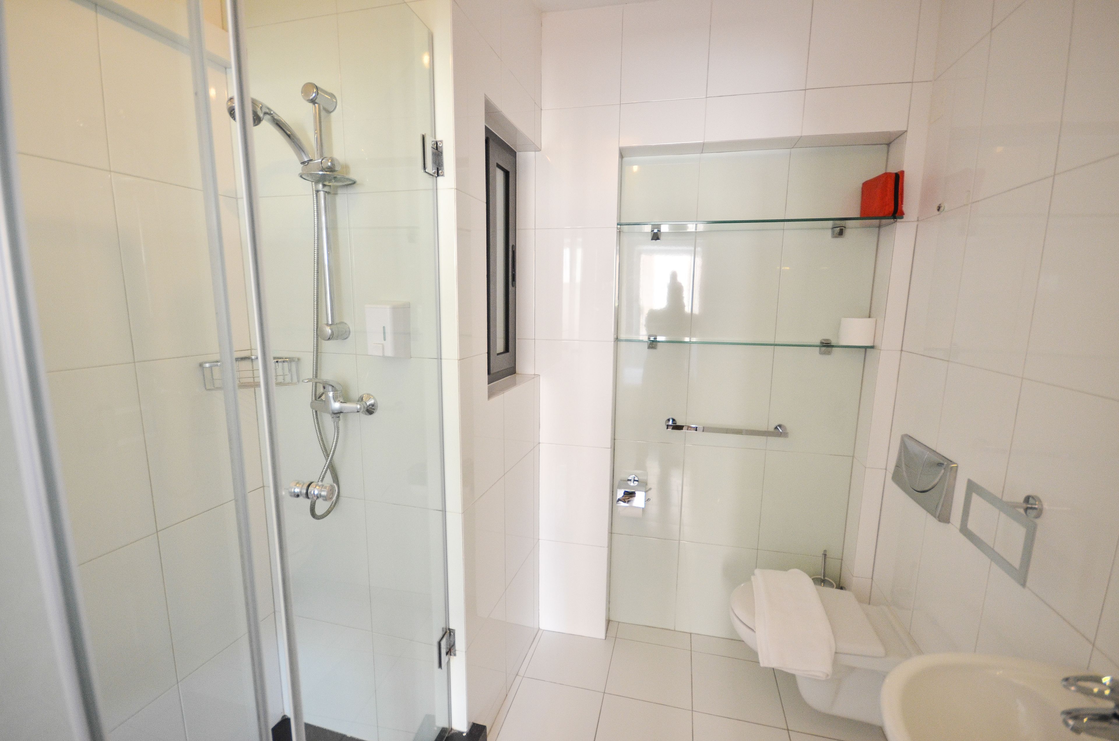 Un bagno moderno con doccia vetrata, un water e un lavandino.