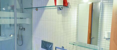 A modern bathroom with a glass shower enclosure, a toilet, a sink, and a mirror.