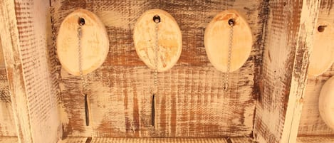 Una estructura de madera rústica con tres aberturas circulares, posiblemente para ventilación o decoración.