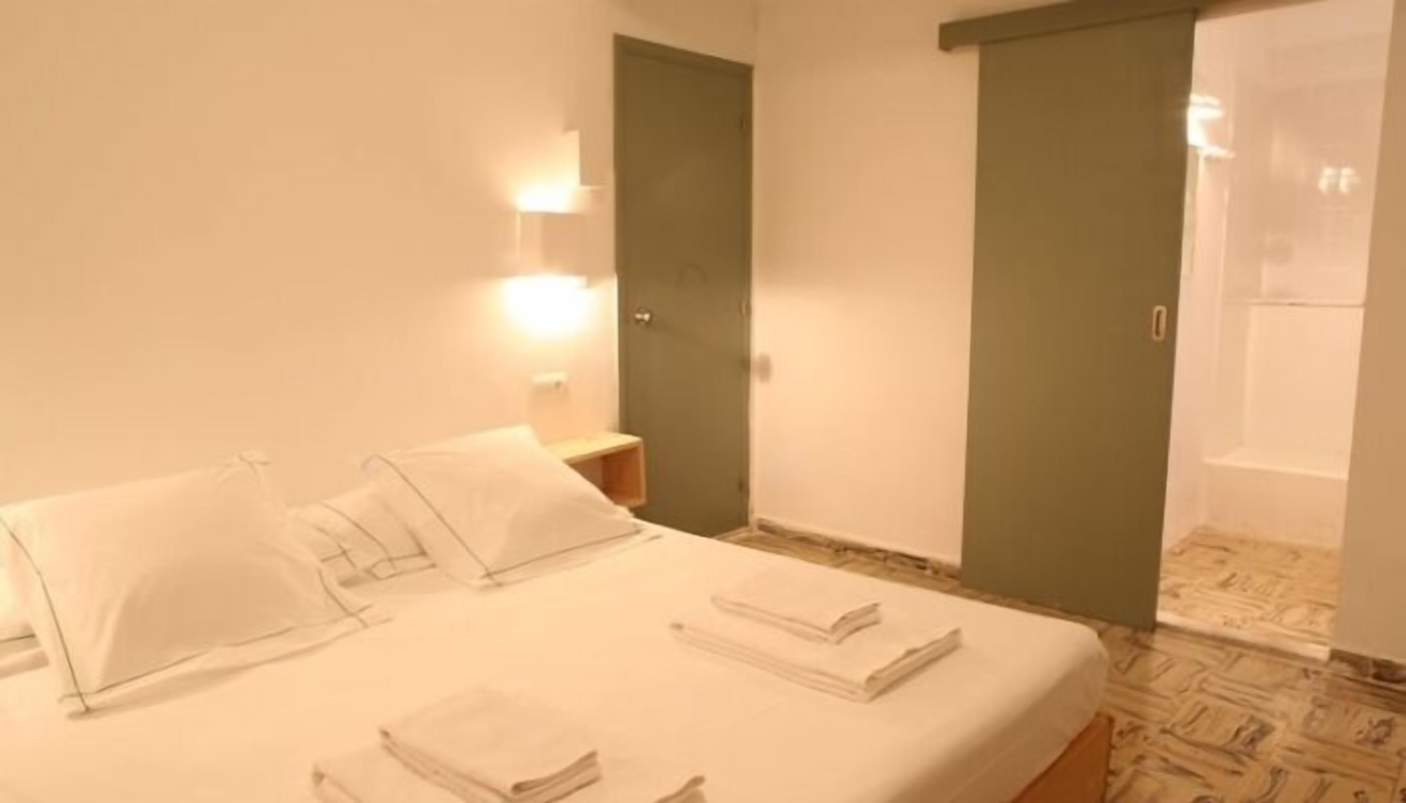 Una habitación de hotel con cama, mesitas de noche y baño.