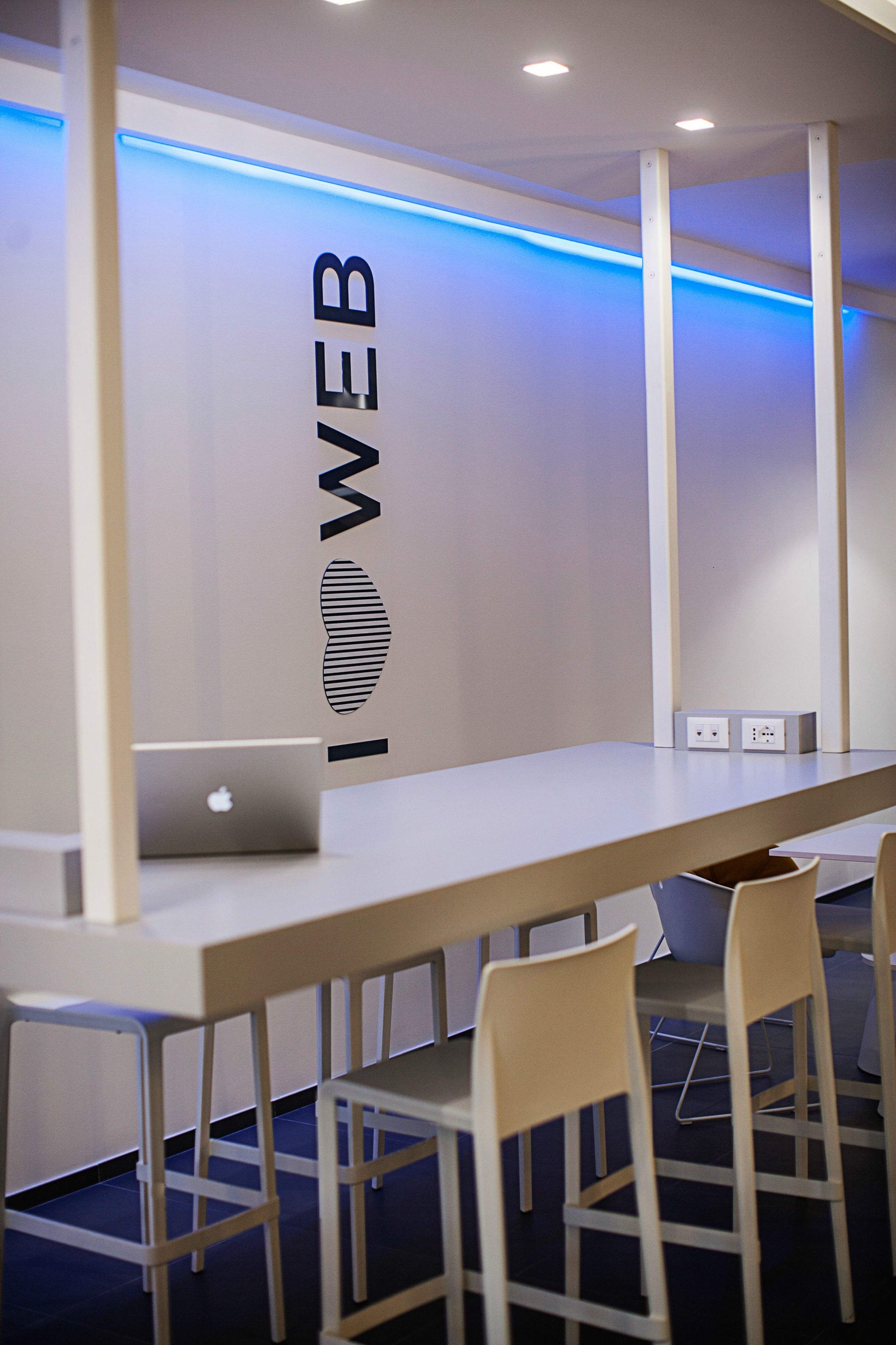A conference room with a long table, several chairs, and a laptop on the table.