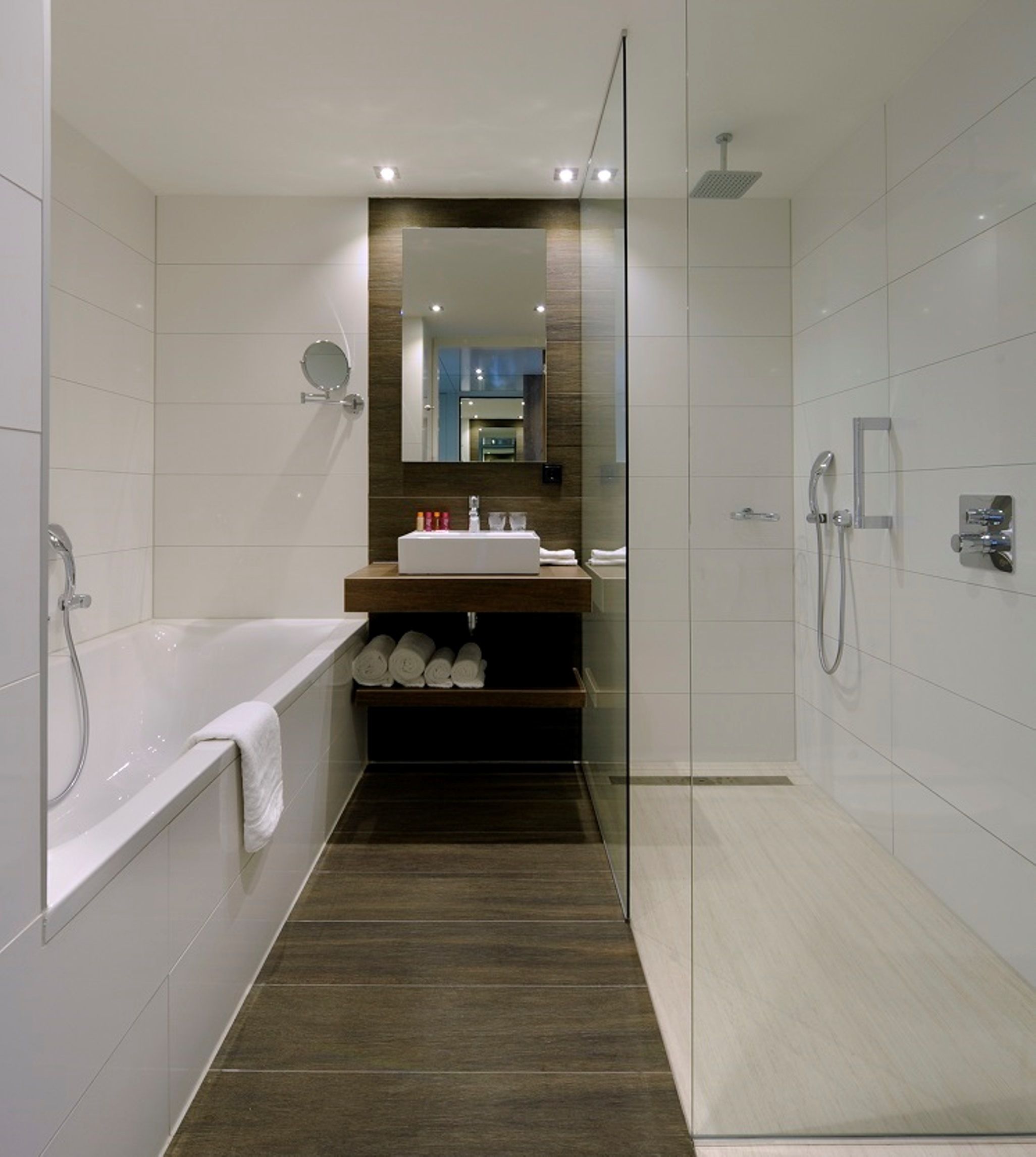 A modern bathroom with a bathtub, a glass-enclosed shower, and a vanity with a mirror.