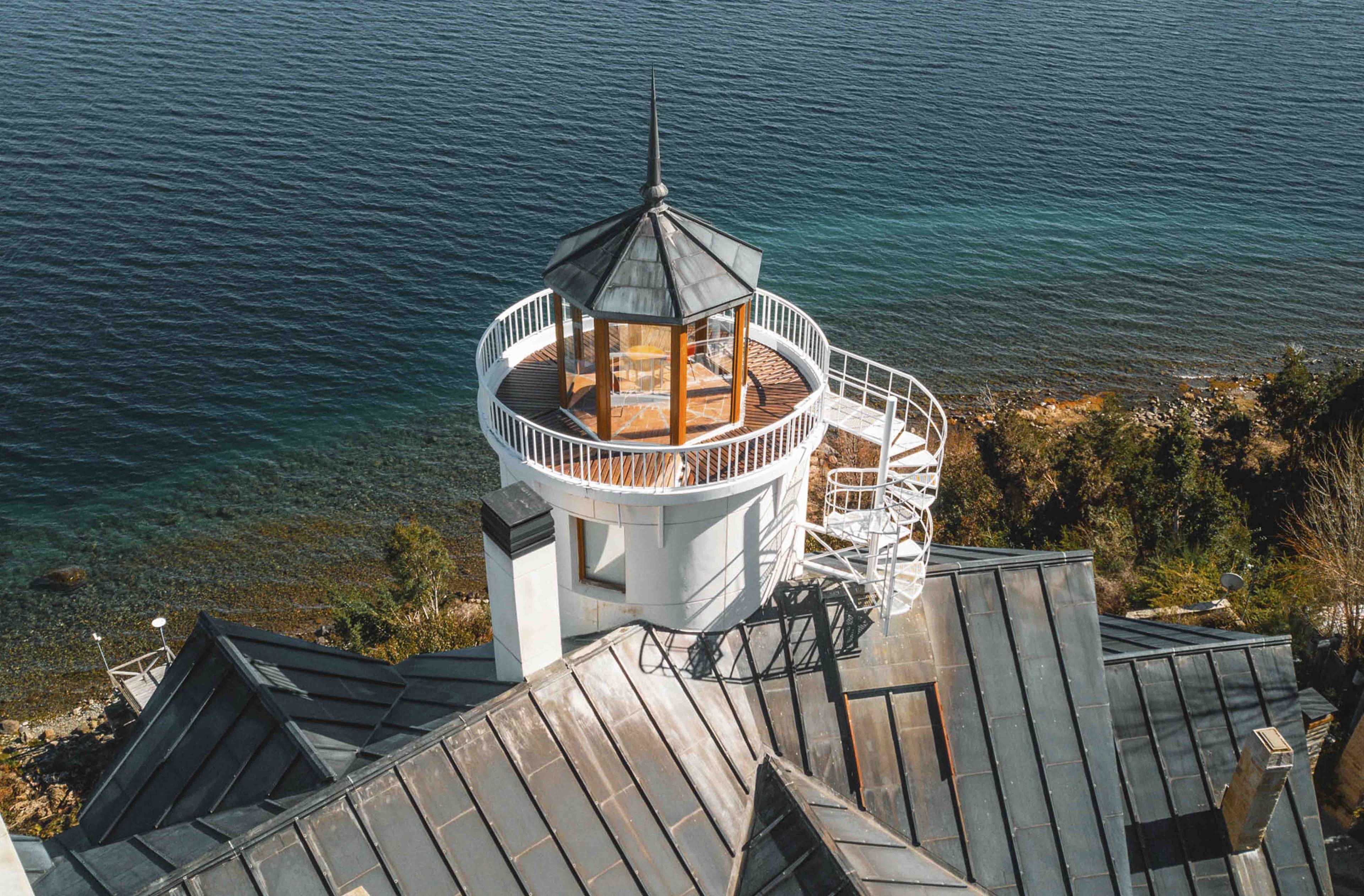 Une tour d’observation circulaire, dotée d’une terrasse en bois et d’un escalier en colimaçon, qui offre une vue sur une étendue d’eau.