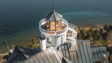 Une tour d’observation circulaire, dotée d’une terrasse en bois et d’un escalier en colimaçon, qui offre une vue sur une étendue d’eau.