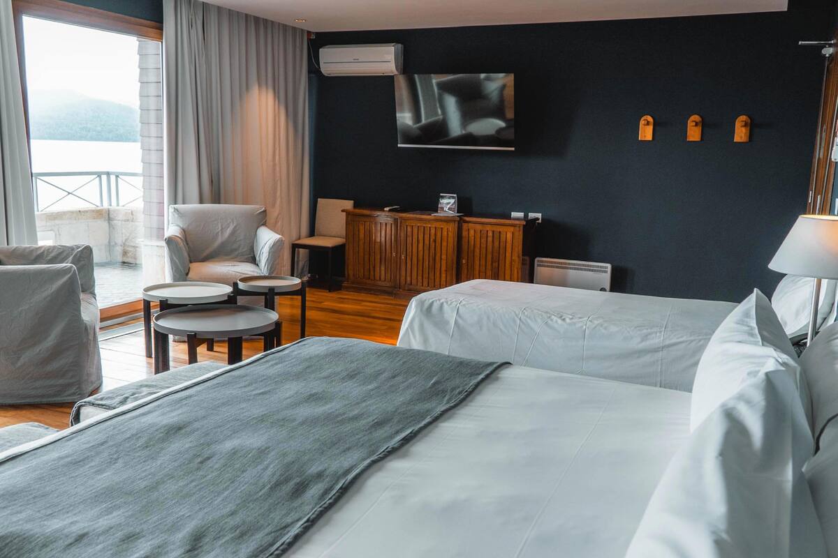 Ett hotellrum med två sängar, en TV, ett träskåp, ett skrivbord och en stol.