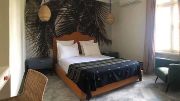 A bedroom with a bed, nightstands, a chair, and a window.