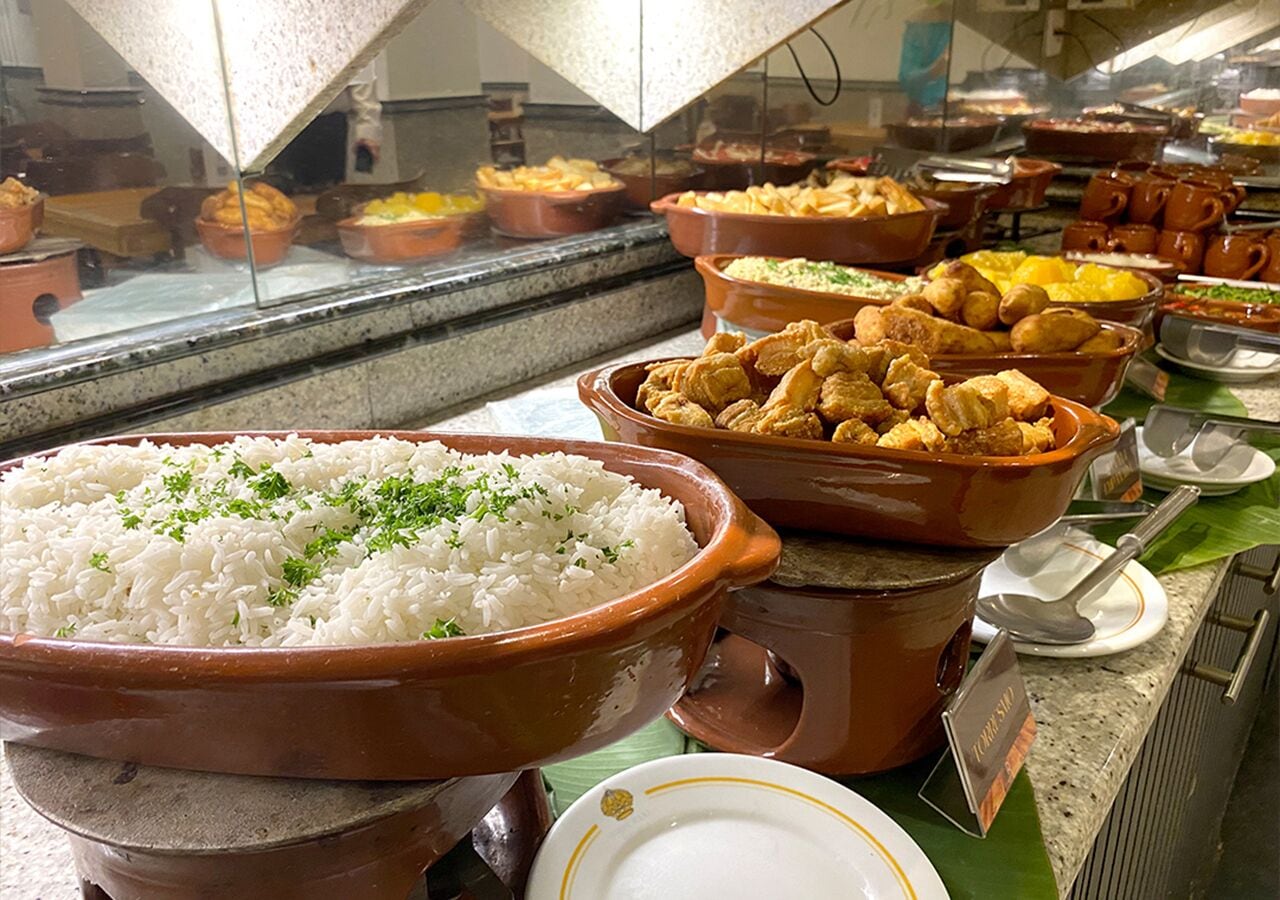 Un buffet proposant divers plats, notamment du riz blanc, du poulet frit et d’autres plats préparés.