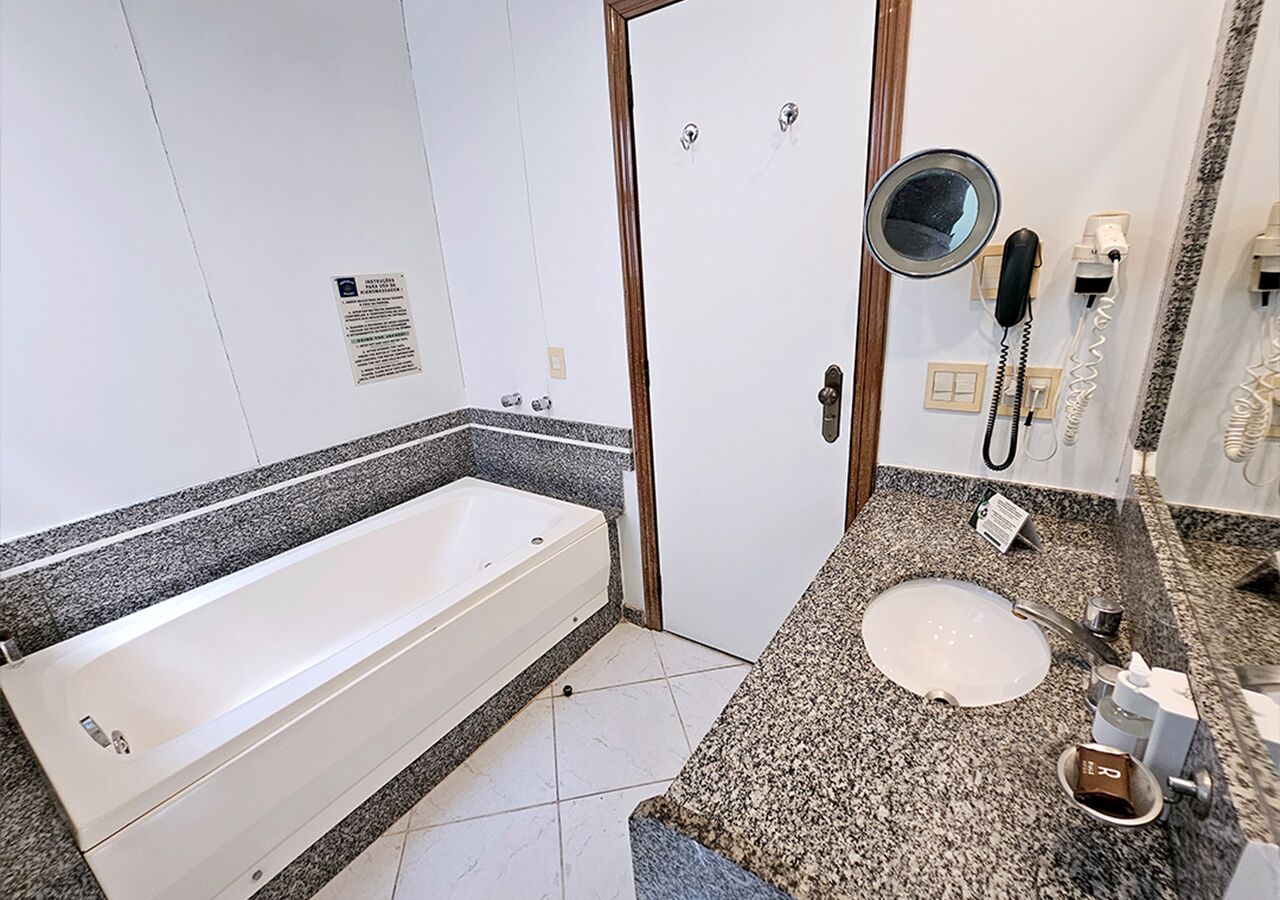 Une salle de bain avec une baignoire, un lavabo et un miroir.
