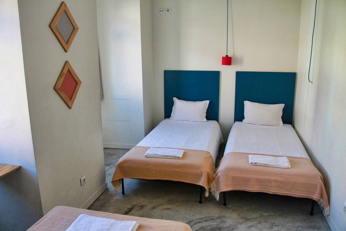Habitación triple, baño compartido | Escritorio, cunas, wifi gratis y ropa de cama