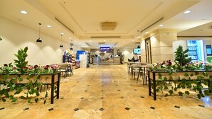 A hotel lobby with a reception desk, seating area, and a vending machine. - Abraj Al Tayseer Tuwa Hotel (Makkah)