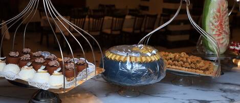 A marble countertop with various desserts displayed on stands.