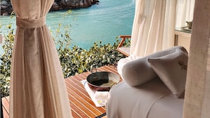 A balcony with a view of the sea, a wooden table with a bowl, and a white pillow. - Awasi Santa Catarina (Governador Celso Ramos)