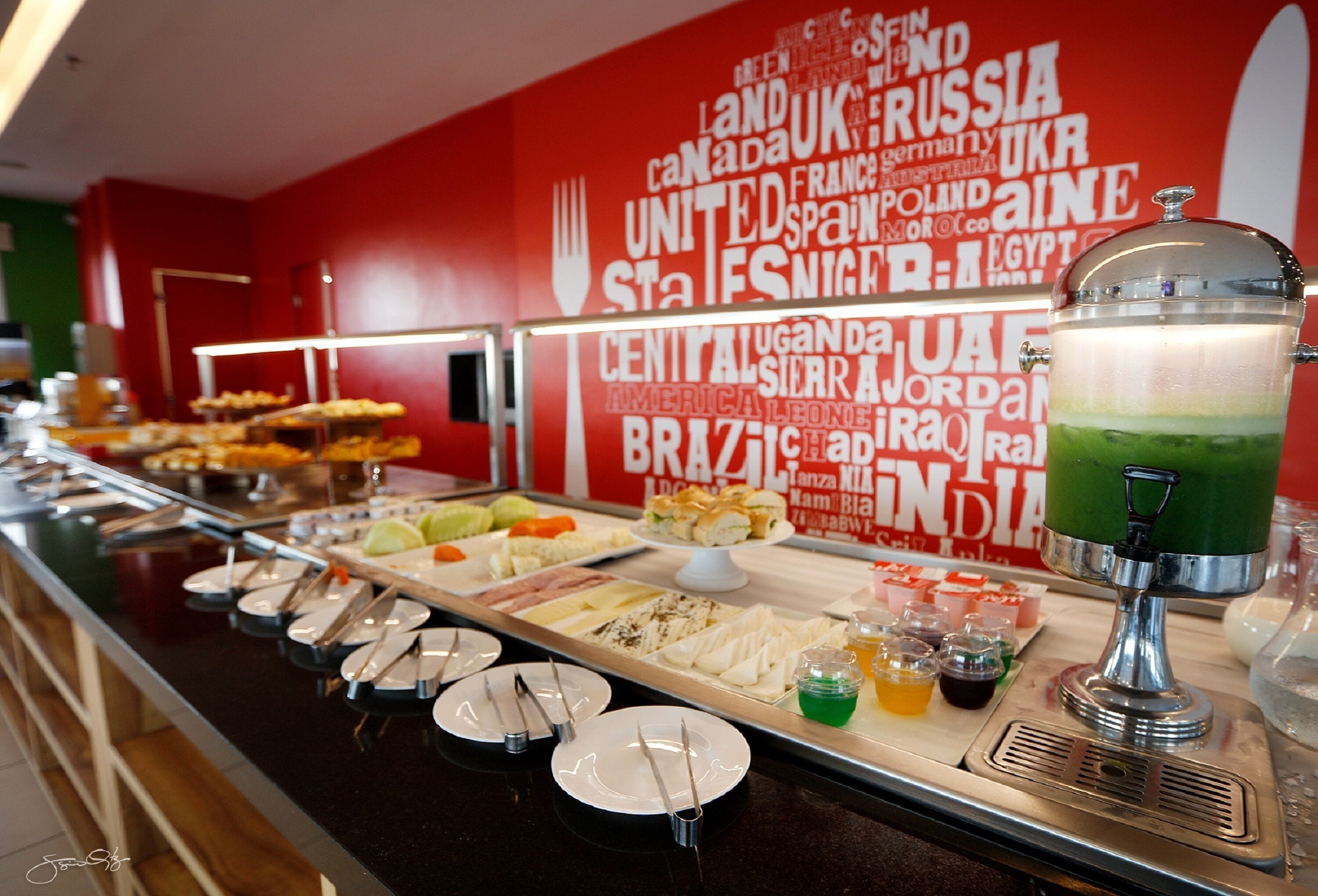 A buffet with various food items and a drink dispenser.