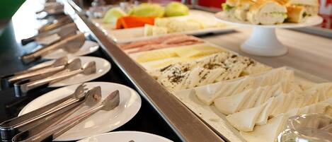 A buffet with various food items and utensils laid out on a counter.