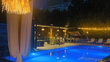 En säsongsöppen utomhuspool, parasoller och solstolar