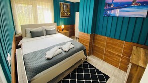 A hotel room with a bed, a painting, and a nightstand. - Royal Loft Suit (Konyaalti)