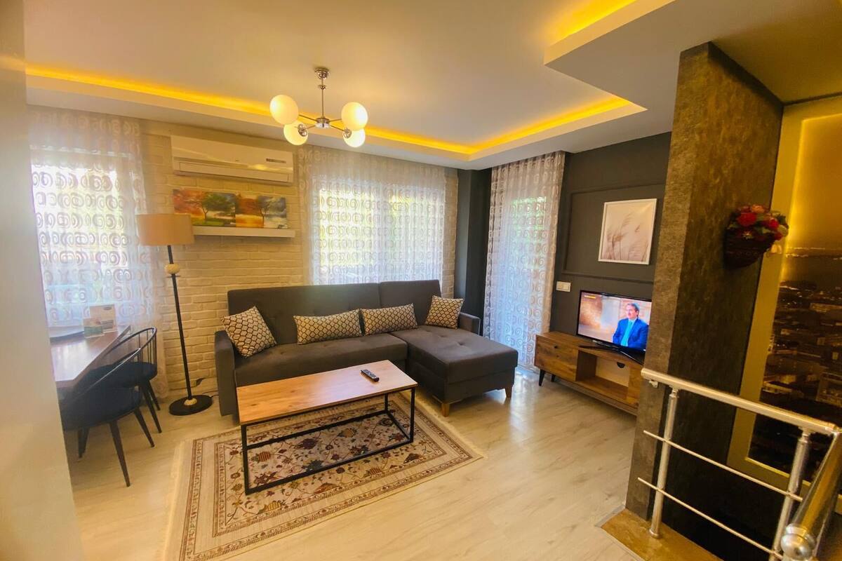 A modern living room with a sofa, coffee table, and TV.
