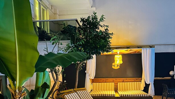 A poolside area with lounge chairs and a seating area with a patterned cushion. - Royal Loft Suit (Konyaalti)