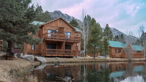 A wooden lodge with a balcony, a pond, and mountains in the background. - Double Eagle Resort & Spa (June Lake)