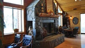A cozy interior with a stone fireplace, wooden ceiling, and large windows. - Double Eagle Resort & Spa (June Lake)