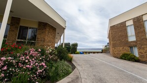 Ein Gebäude mit überdachtem Gang, Ziegelaußenwand und Parkplatz.