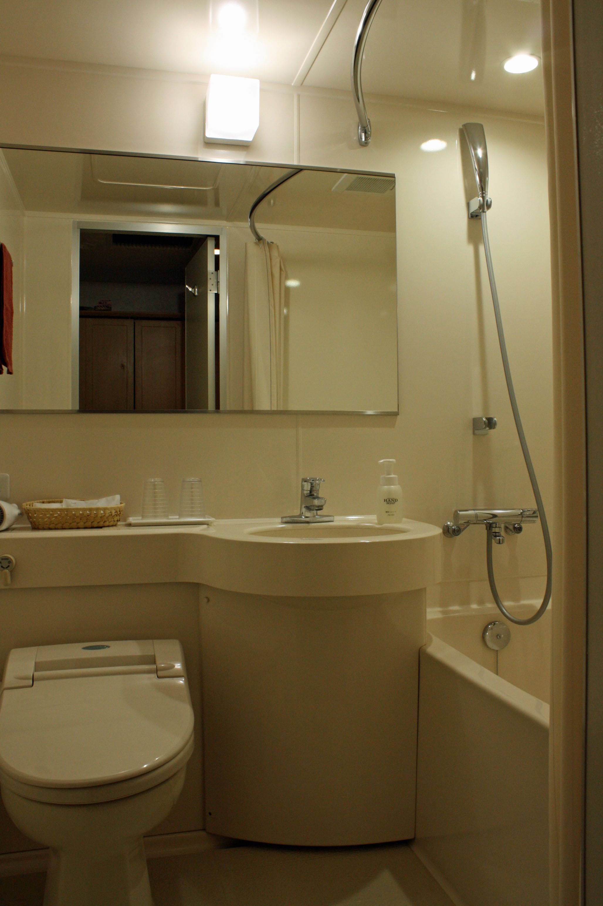 Une salle de bain équipée de toilettes, d’un lavabo et d’une douche.