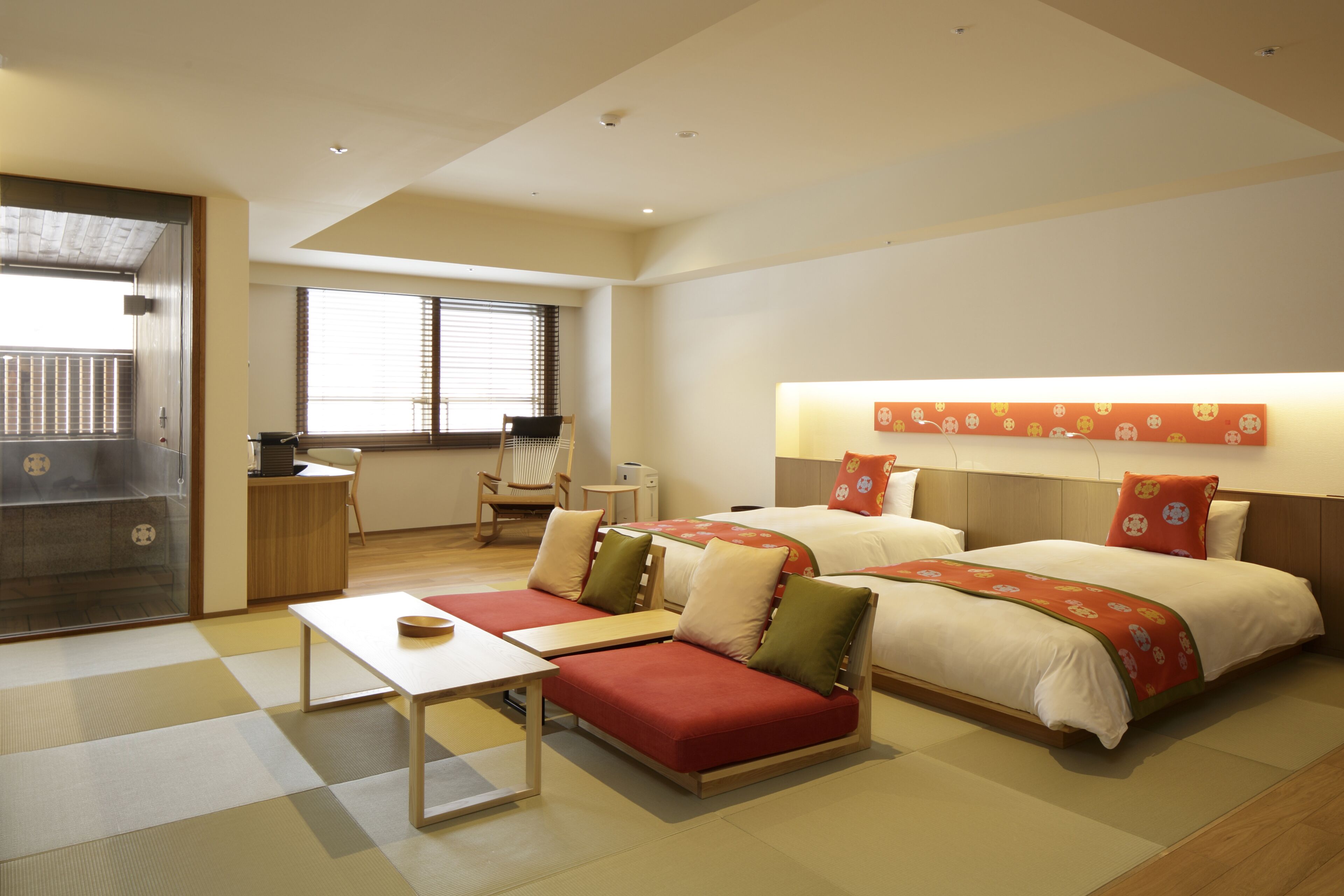 Une chambre d’hôtel avec un canapé-lit, un bureau et un lit avec une tête de lit.