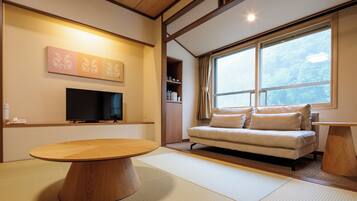 Una sala moderna con una mesa de comedor de madera, un sofá y un ventanal con vistas al exterior.