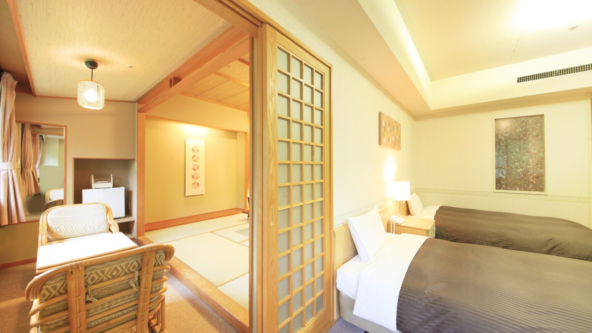 Una habitación de hotel con cama, una silla, escritorio y espejo, además de una puerta corredera.