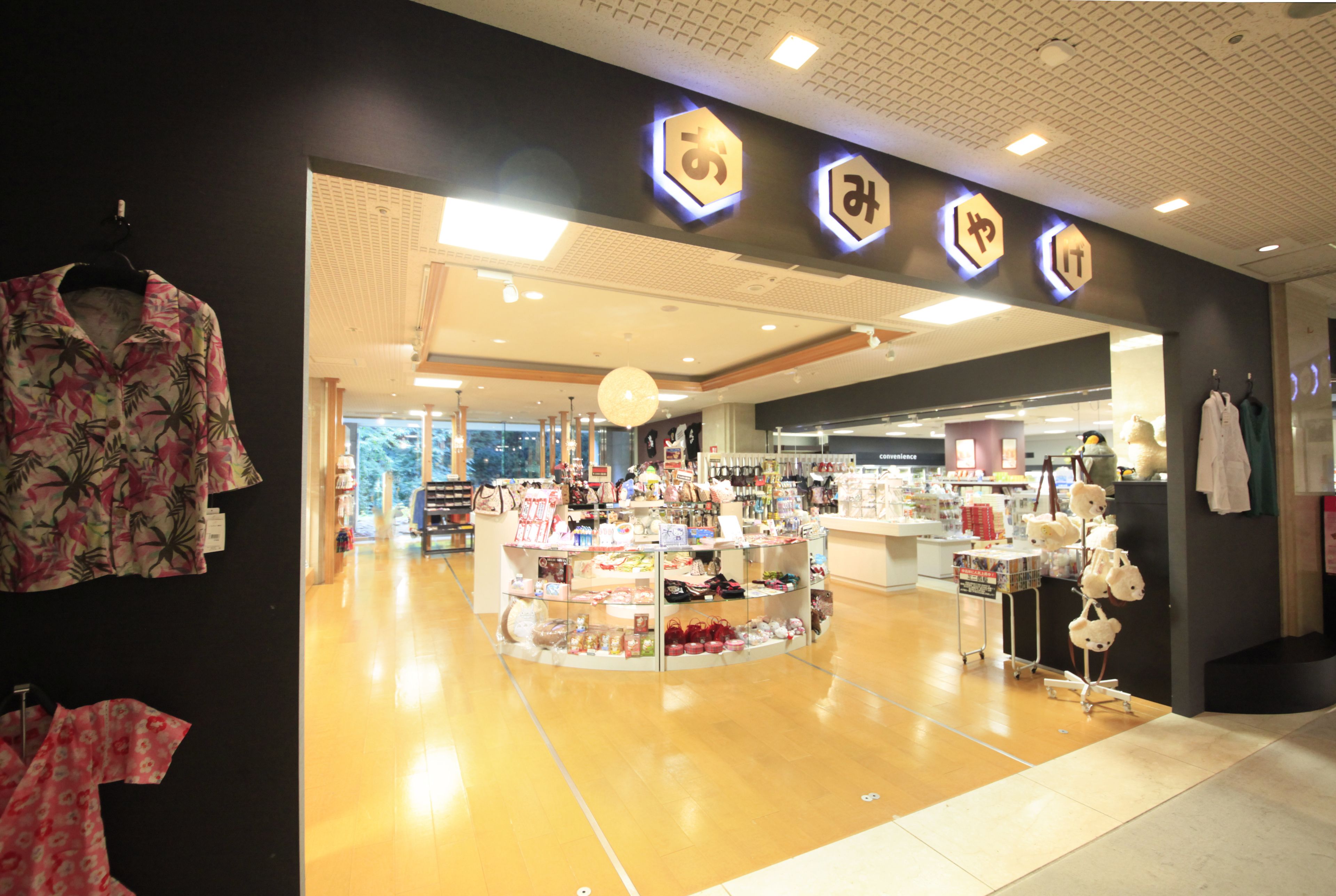 Un magasin doté d’un plancher en bois, d’un présentoir central et d’une enseigne avec des lettres illuminées.
