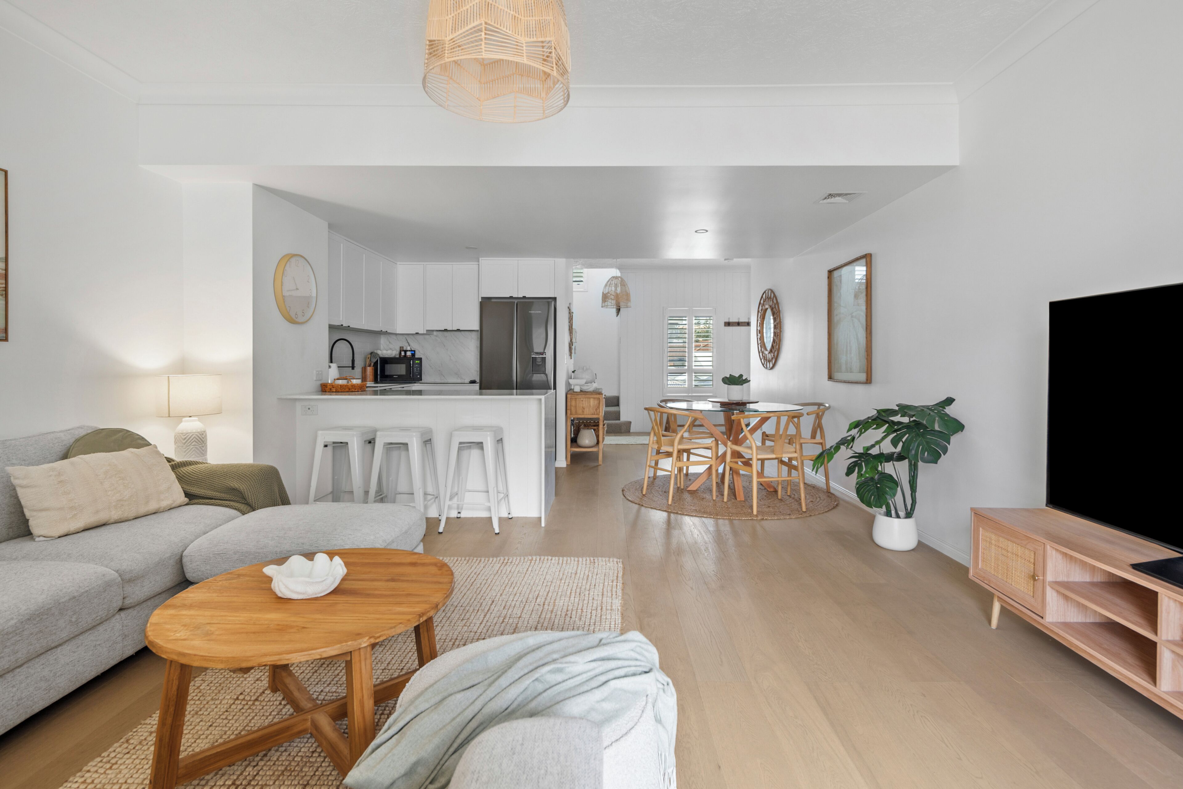 Una sala de estar moderna con un sofá, una mesa de centro y un mueble para la televisión.