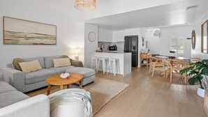 Un salon moderne comprenant un canapé, une table basse et un coin repas avec des chaises et une table.