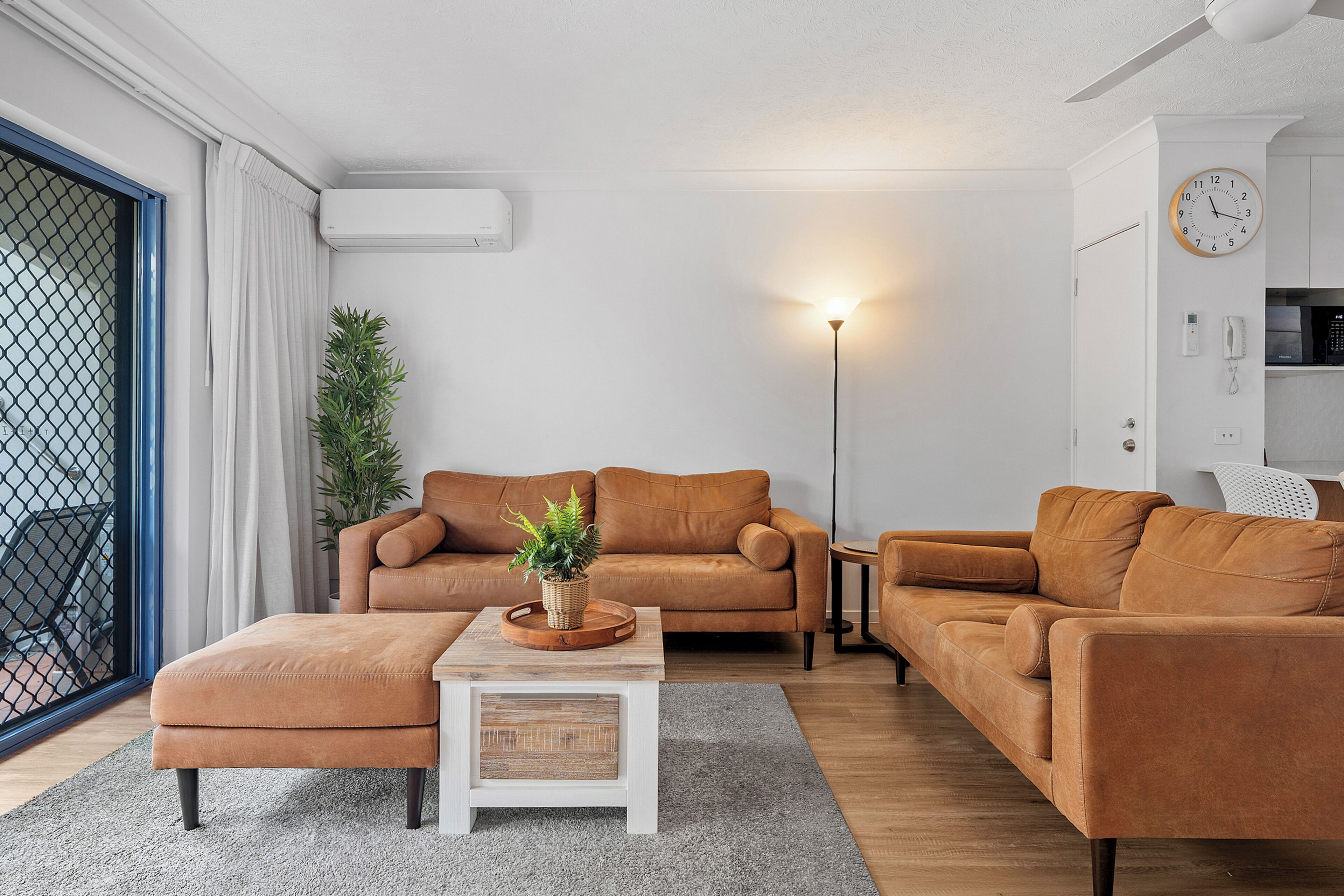 A modern living room with a sofa set, a coffee table, and a floor lamp.