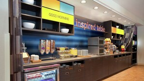 A modern kitchen area with a breakfast bar, a refrigerator, and a microwave. - Home2 Suites by Hilton San Antonio Airport, TX (San Antonio)