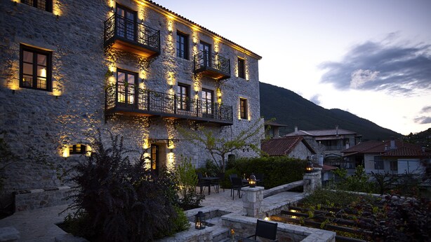 A stone building with multiple balconies and outdoor seating. - Villa Vager (Tripoli)