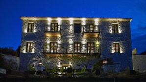A stone building with multiple balconies and illuminated windows at night. - Villa Vager (Tripoli)