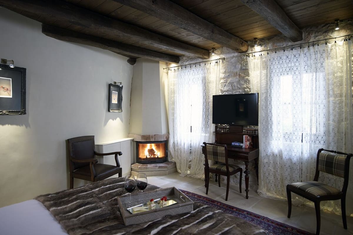 A cozy living room with a fireplace, a television, and comfortable seating.