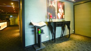 A hotel room with a reception desk, a desk with a lamp, and a poster on the wall. - Taipei 101 SPARKLE Hotel (Taipei)