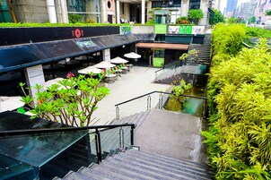 Een trap die leidt naar een terras op het dak, met buitenmeubels en beplanting.